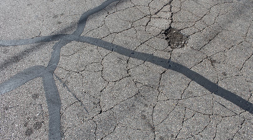 A Tar Road With Cracks on the Surface
